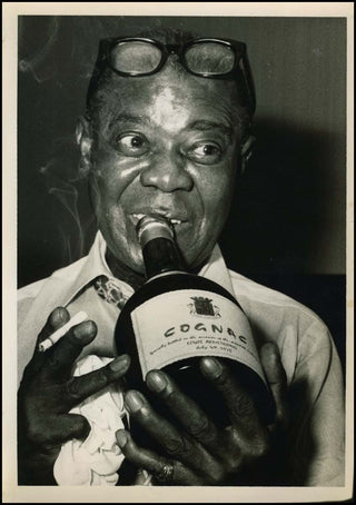 Armstrong, Louis. (1901–1971) Original Photograph drinking Cognac from the Bottle